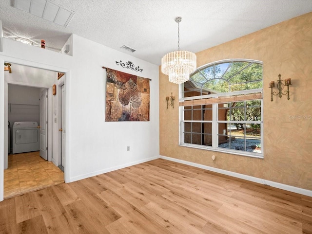 unfurnished dining area with visible vents, baseboards, wood finished floors, a notable chandelier, and a textured ceiling