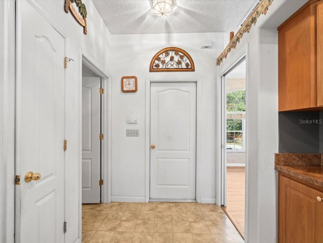 entryway with a textured ceiling and baseboards