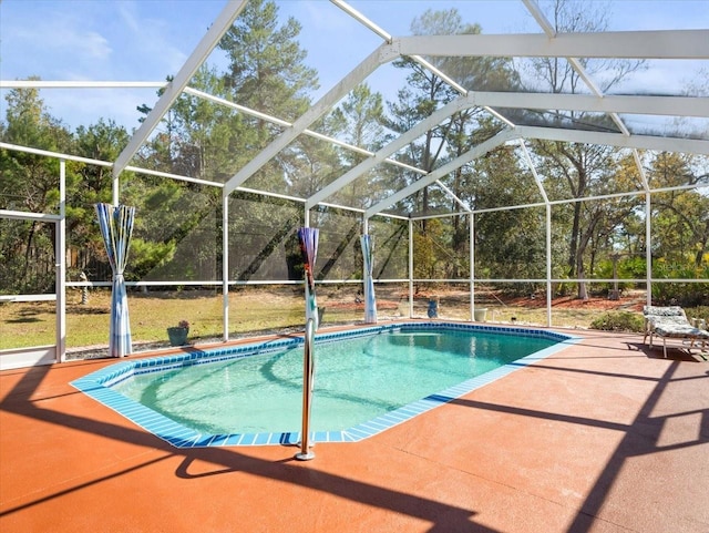 pool featuring glass enclosure and a patio area