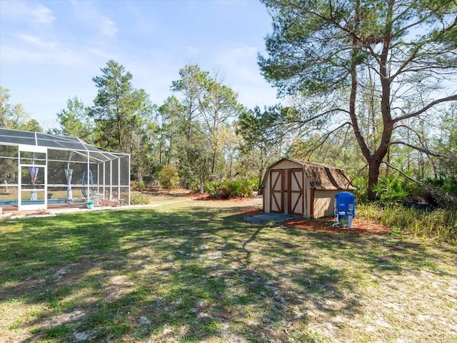 view of yard featuring an outbuilding, a storage shed, a pool, and a lanai