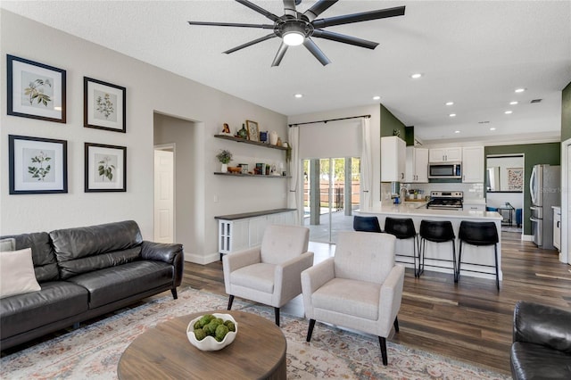 living room featuring dark wood-style floors, recessed lighting, a textured ceiling, and baseboards