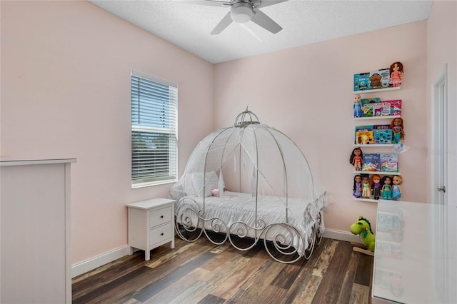 bedroom featuring a textured ceiling, wood finished floors, baseboards, and ceiling fan