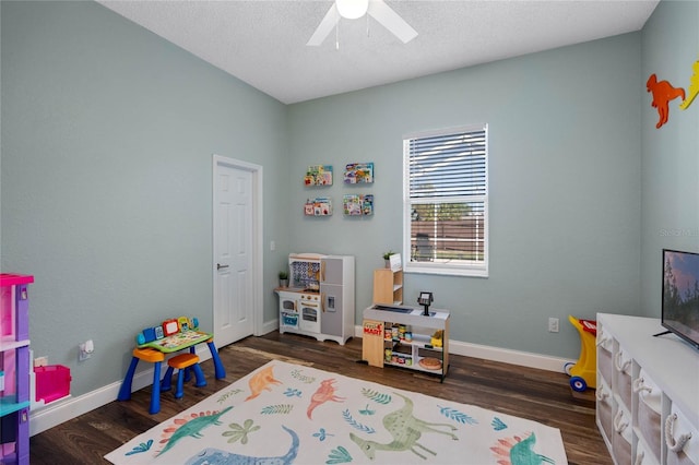 rec room with baseboards, a textured ceiling, and wood finished floors