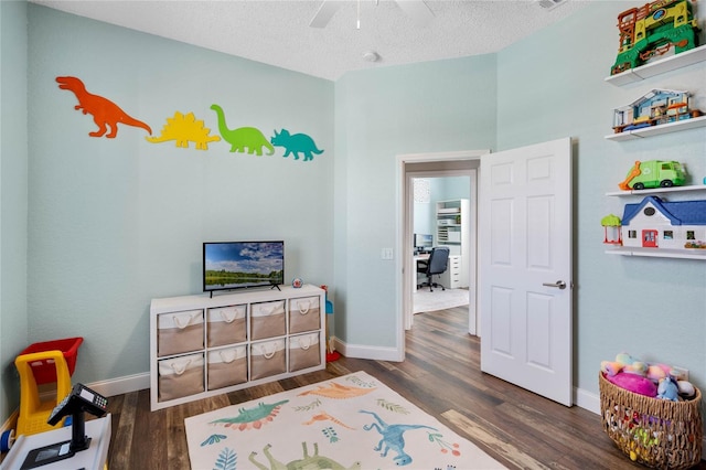 playroom featuring baseboards, a textured ceiling, ceiling fan, and dark wood-style flooring