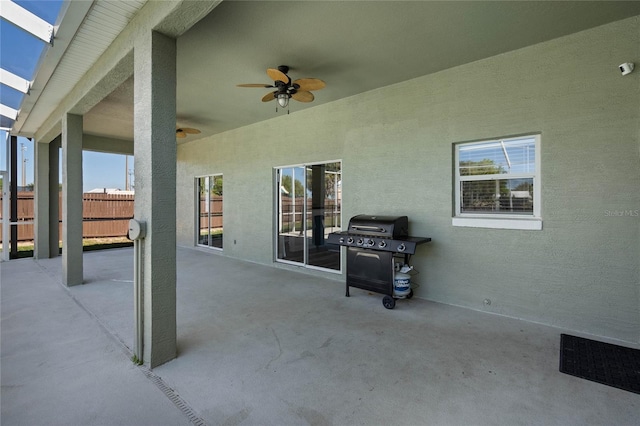 view of patio featuring a grill, ceiling fan, and fence