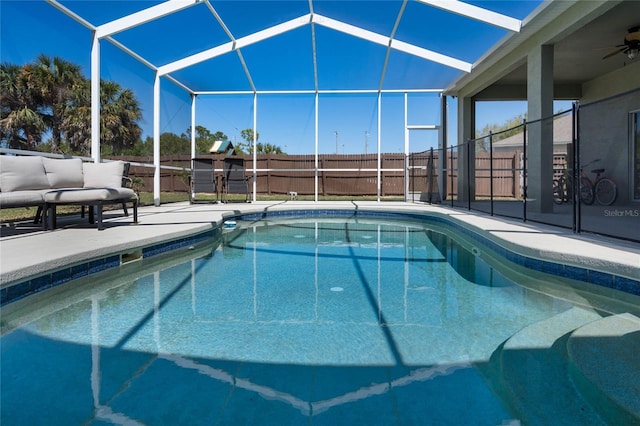 view of pool featuring fence, a lanai, a fenced in pool, ceiling fan, and a patio area