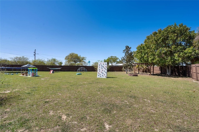 view of yard with a fenced backyard and a trampoline