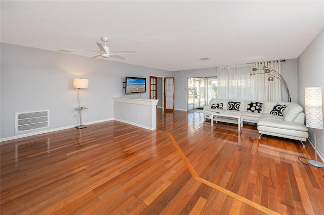 unfurnished living room with visible vents, baseboards, a ceiling fan, and hardwood / wood-style flooring