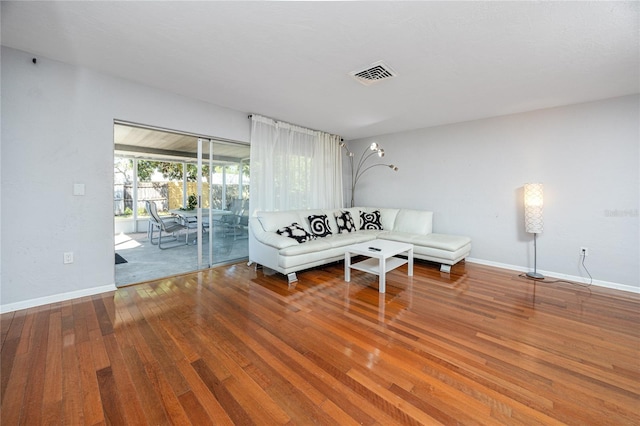 living area featuring visible vents, baseboards, and hardwood / wood-style flooring