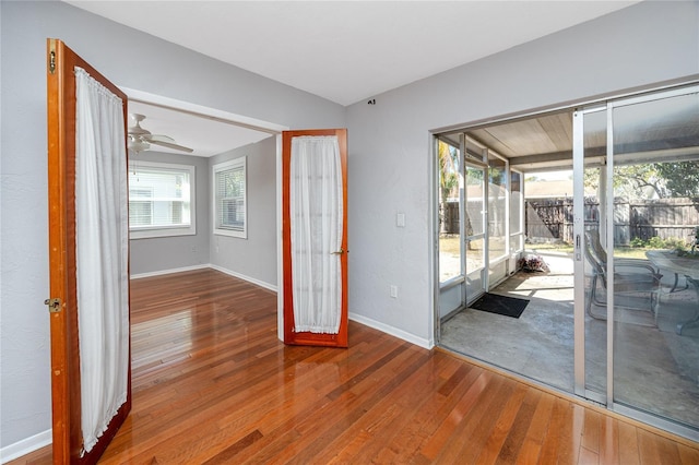 empty room with hardwood / wood-style flooring, a healthy amount of sunlight, and baseboards