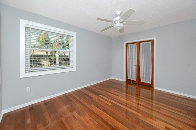 spare room featuring a ceiling fan, wood finished floors, and baseboards