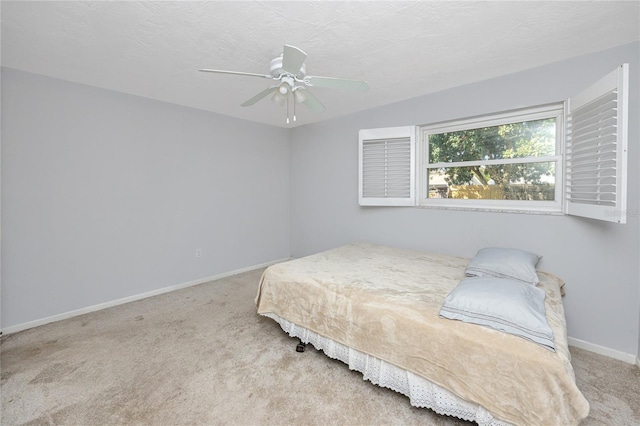 carpeted bedroom with a ceiling fan, baseboards, and a textured ceiling