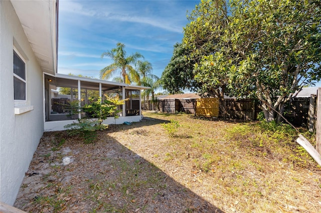 view of yard featuring a fenced backyard and a sunroom