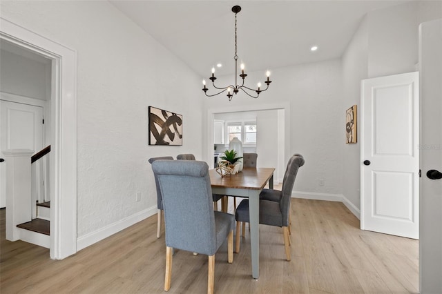 dining area featuring a notable chandelier, baseboards, and light wood-type flooring