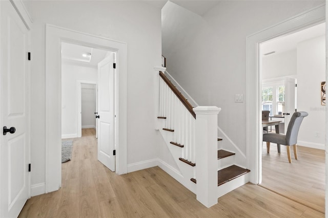 stairs with wood finished floors and baseboards