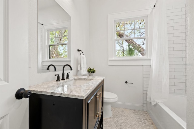 bathroom with shower / bath combo with shower curtain, baseboards, toilet, and vanity