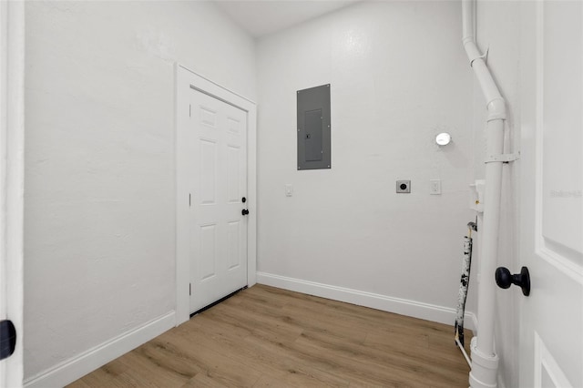 laundry area with electric panel, light wood finished floors, baseboards, hookup for an electric dryer, and laundry area