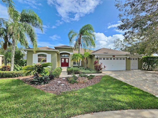 view of front of home with concrete driveway, an attached garage, a front lawn, and stucco siding