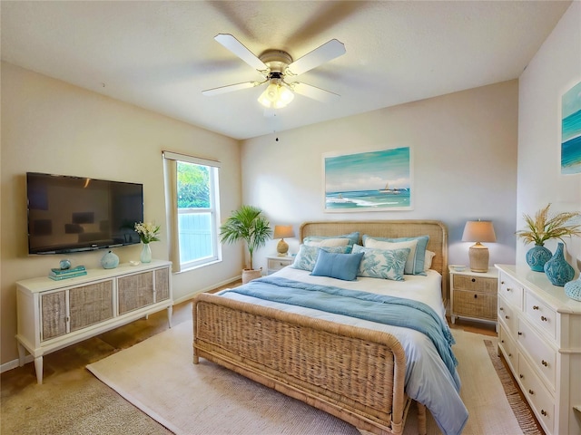 bedroom with ceiling fan and light carpet