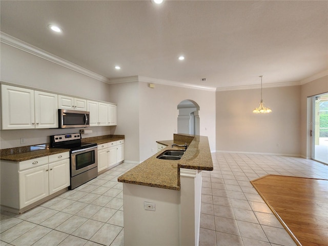 kitchen featuring white cabinetry, light tile patterned flooring, appliances with stainless steel finishes, and ornamental molding