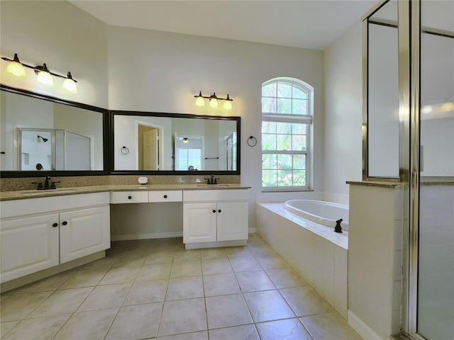 bathroom with double vanity, a stall shower, a sink, tile patterned flooring, and a bath