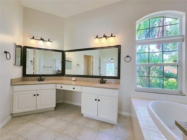 bathroom featuring tile patterned flooring, double vanity, a bath, and a sink