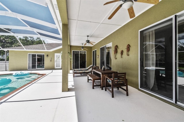 view of patio featuring glass enclosure, a ceiling fan, and an outdoor pool