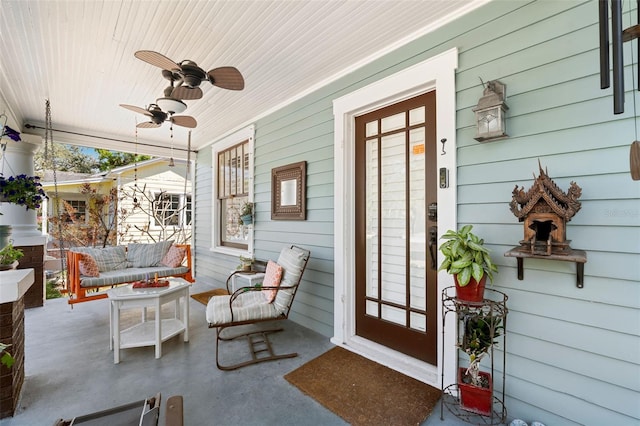 view of exterior entry featuring covered porch, an outdoor hangout area, and ceiling fan