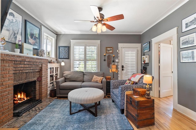 living room featuring crown molding, wood finished floors, a fireplace, and baseboards