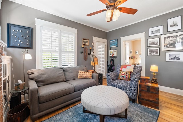 living room featuring ornamental molding, ceiling fan, baseboards, and wood finished floors