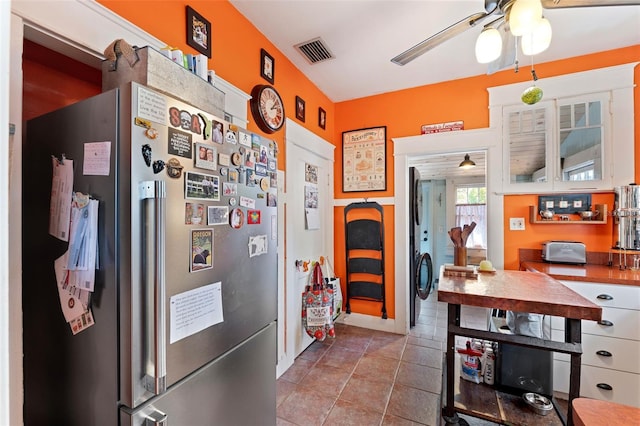 kitchen with tile patterned floors, visible vents, freestanding refrigerator, and ceiling fan