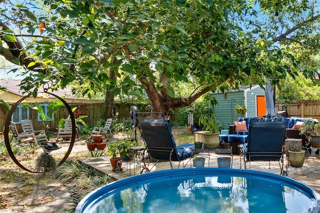 view of pool featuring an outdoor structure, a fenced backyard, and a patio