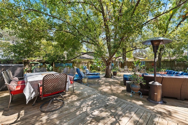 wooden deck with outdoor dining area and a fenced backyard