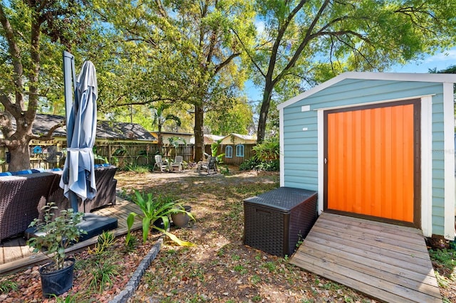 view of yard featuring a storage unit, an outdoor structure, and fence