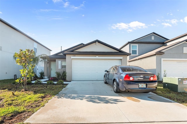 view of front facade with concrete driveway, an attached garage, and stucco siding