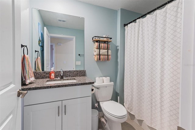 bathroom with curtained shower, toilet, and vanity