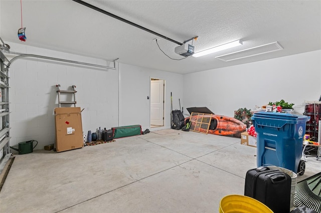 garage with concrete block wall and a garage door opener