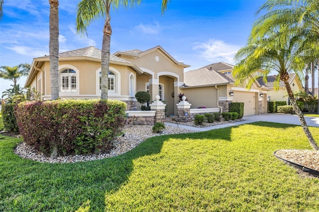 mediterranean / spanish house with a front yard, driveway, an attached garage, a shingled roof, and stucco siding