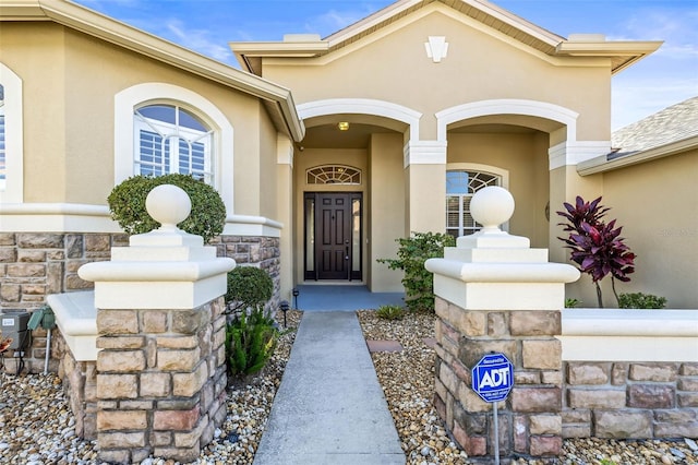 doorway to property with stucco siding and stone siding