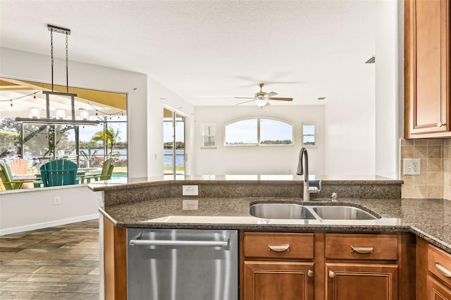 kitchen with dishwasher, a healthy amount of sunlight, brown cabinets, and a sink