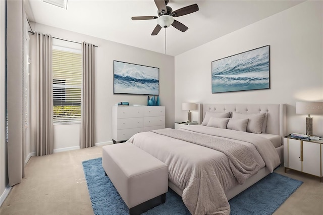 bedroom featuring baseboards, light carpet, and ceiling fan