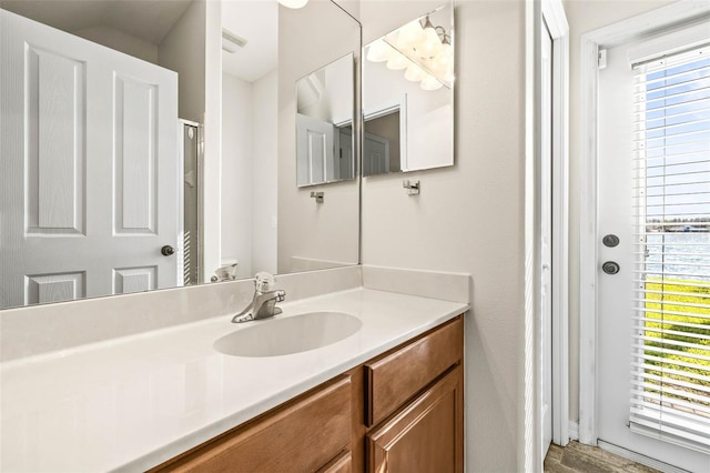 full bath with vanity, a shower, and visible vents