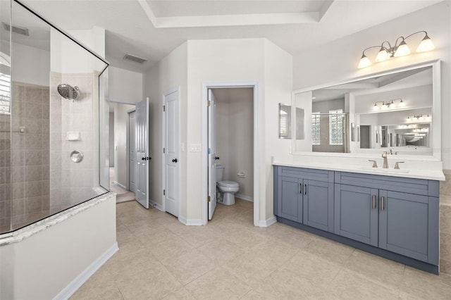 full bathroom with visible vents, toilet, vanity, and a tile shower