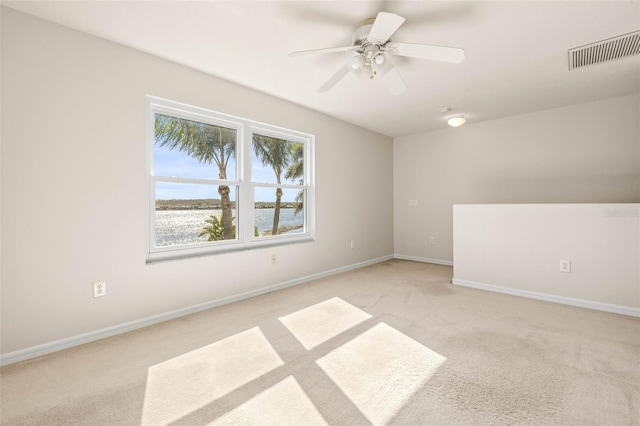 unfurnished room featuring visible vents, baseboards, light colored carpet, and ceiling fan