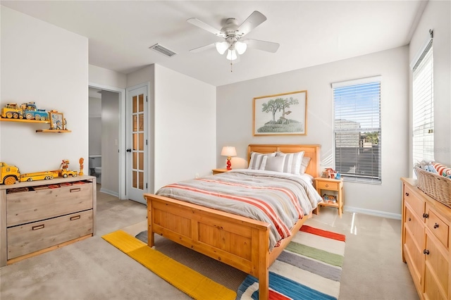 bedroom featuring visible vents, baseboards, light colored carpet, and a ceiling fan