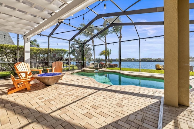 view of pool with a patio area, a pool with connected hot tub, a lanai, and a water view