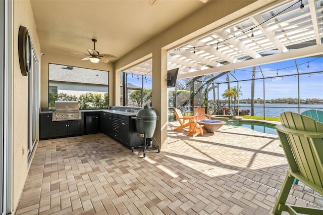 view of patio featuring glass enclosure, a ceiling fan, a pool with connected hot tub, a water view, and grilling area