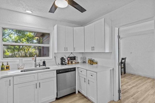 kitchen featuring a sink, white cabinets, light countertops, and stainless steel dishwasher