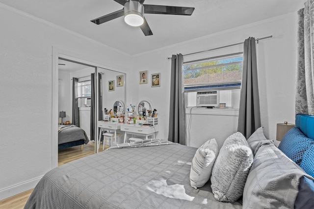 bedroom featuring ornamental molding, cooling unit, multiple windows, and wood finished floors