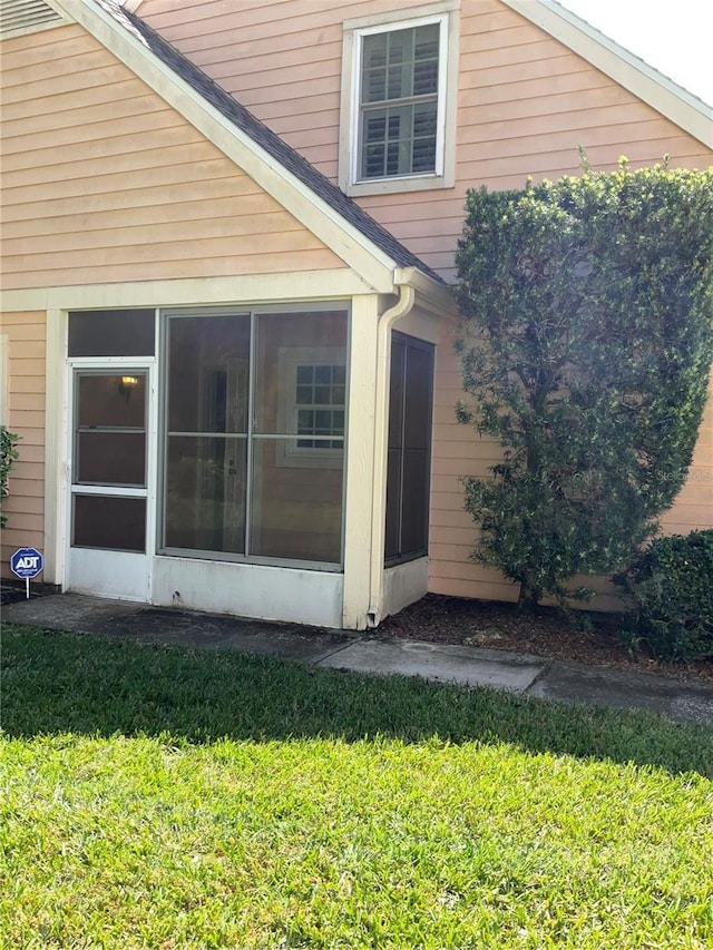 view of home's exterior featuring a yard and a sunroom